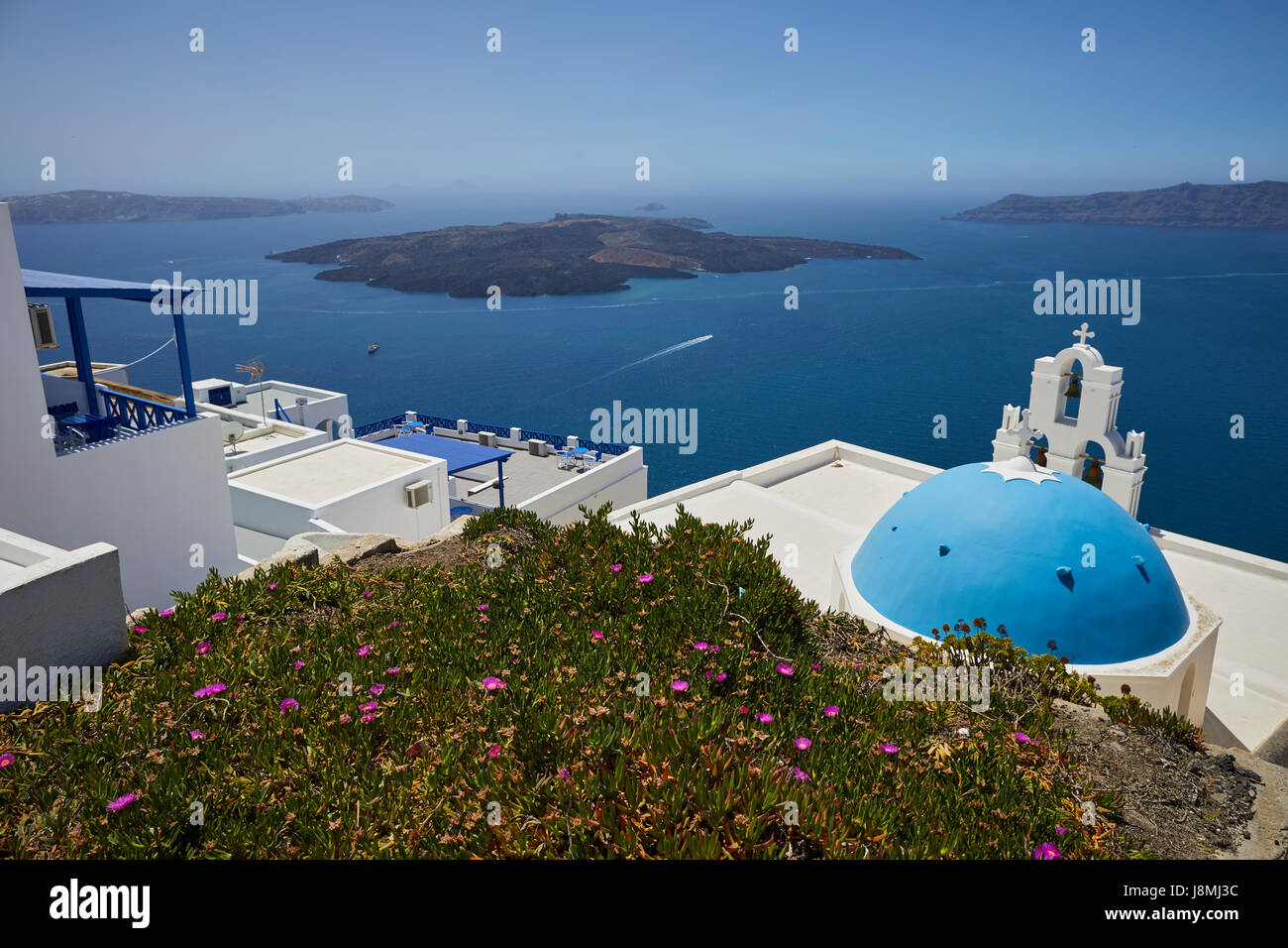 Vulcanica isola greca Santorini una delle isole Cicladi nel Mare Egeo. Fira capitale isole simbolo principale tre campane di Fira e blu Foto Stock