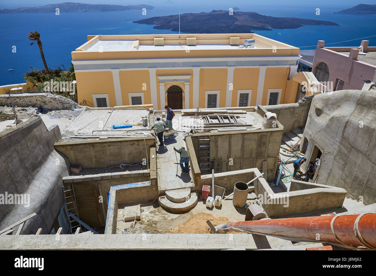 Vulcanica isola greca Santorini una delle isole Cicladi nel Mare Egeo. Fira capitale isole, operai edificio sulla ripida scogliera Foto Stock