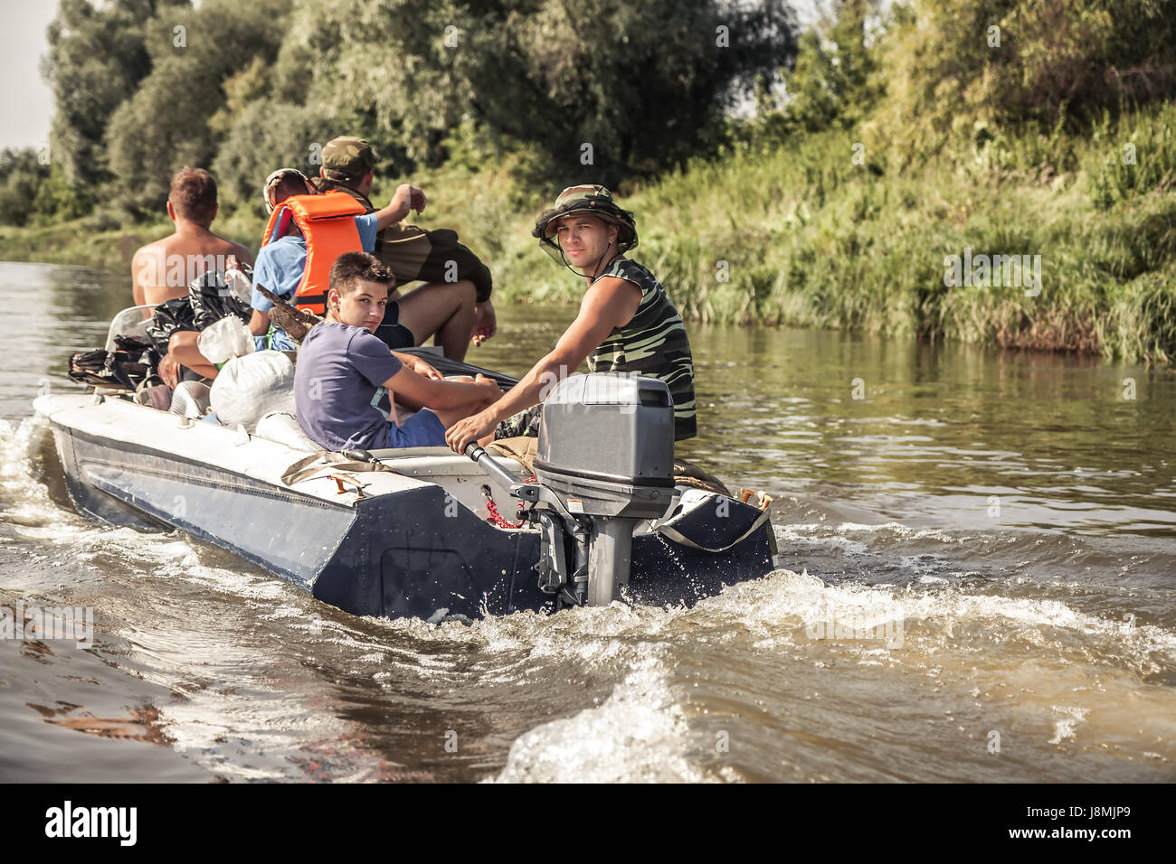 Un gruppo di uomini sulla vela imbarcazione a motore dal fiume per la caccia camp durante la stagione di caccia Foto Stock