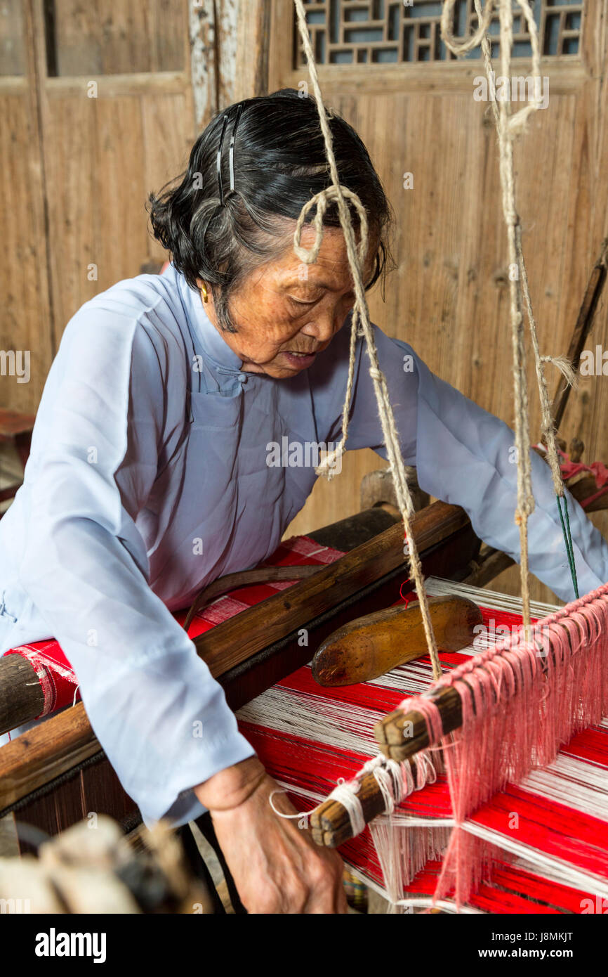 Yubei, Zhejiang, Cina. Senior tessitura donna al suo telaio. Foto Stock