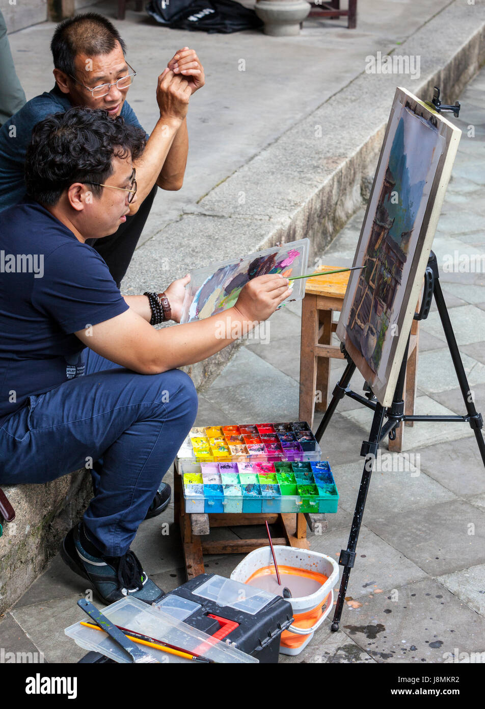 Linkeng, Zhejiang, Cina. Artista pittura una scena del villaggio. Foto Stock