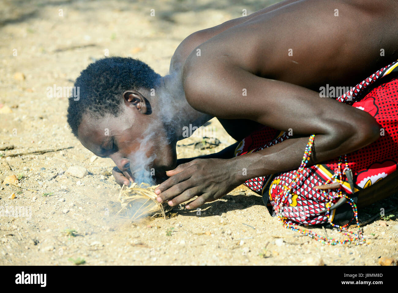 Samburu uomini innescando un incendio nel modo tradizionale. Essi utilizzano uno o due bastoni per generare calore e creare la prima fiamma. Foto Stock