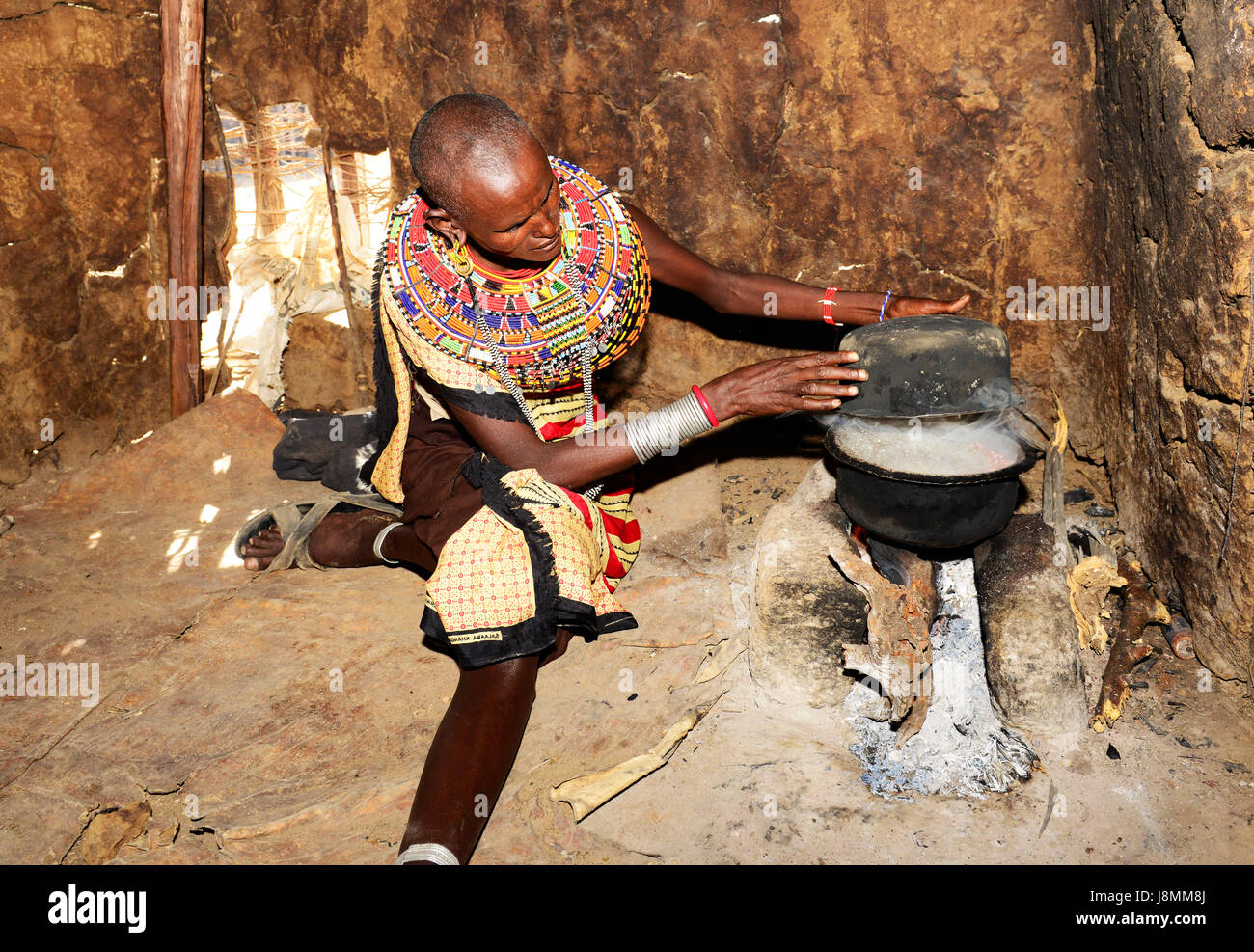 Un Samburu donna la cottura nel suo rifugio in un piccolo villaggio nel nord del Kenya. Foto Stock
