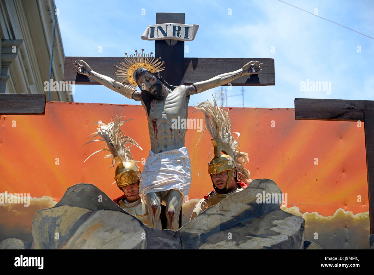 Attori che interpretano i soldati romani appendere una statua di Gesù su un crocifisso al 2014 processione del Venerdì Santo a San José di Costa Rica. Foto Stock