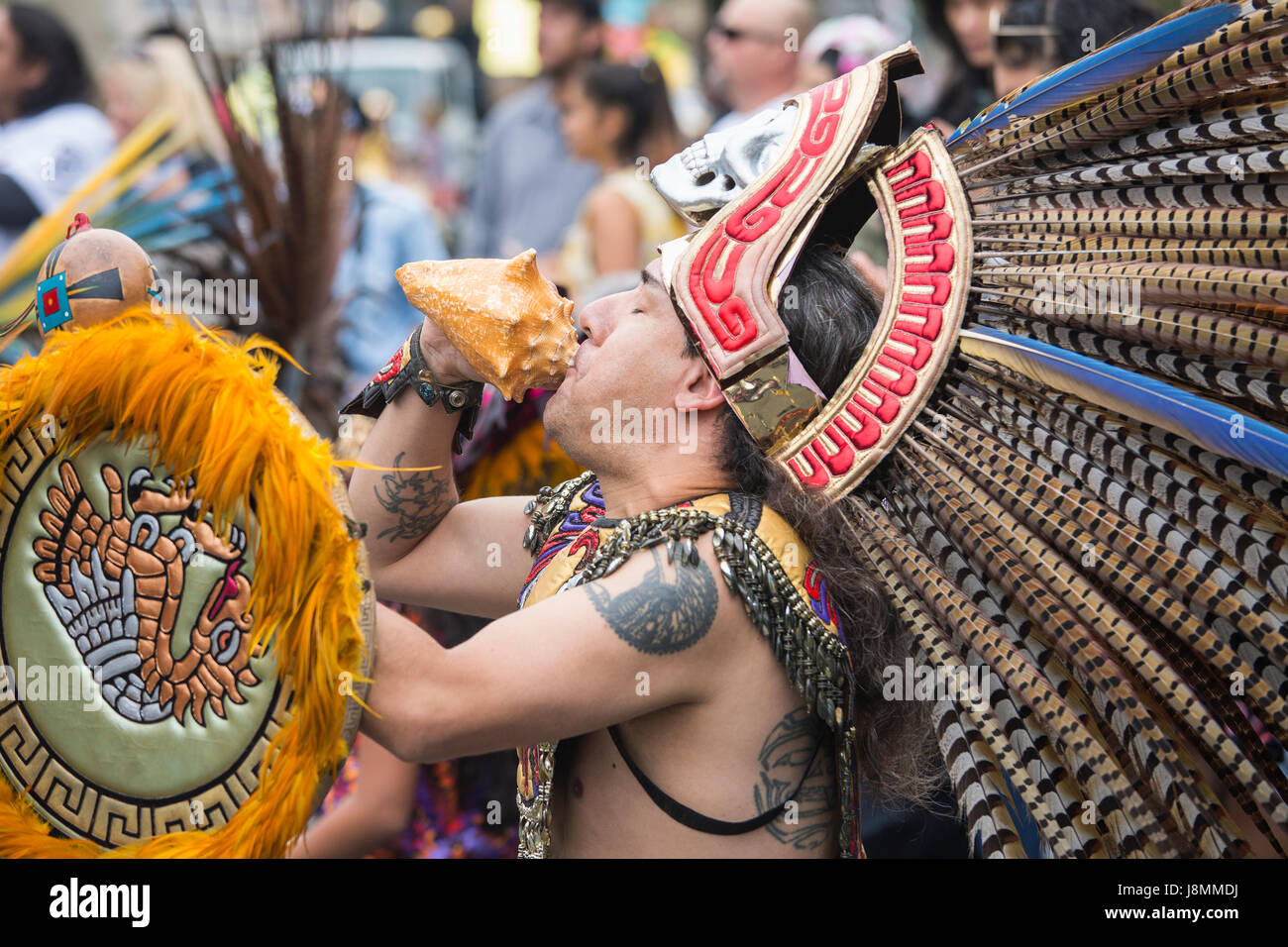 Gli stati di Xiuhcoatl Danza Azteca insufflando nella shell durante la cerimonia alla sfilata di carnevale a San Francisco nel distretto di missione. Foto Stock