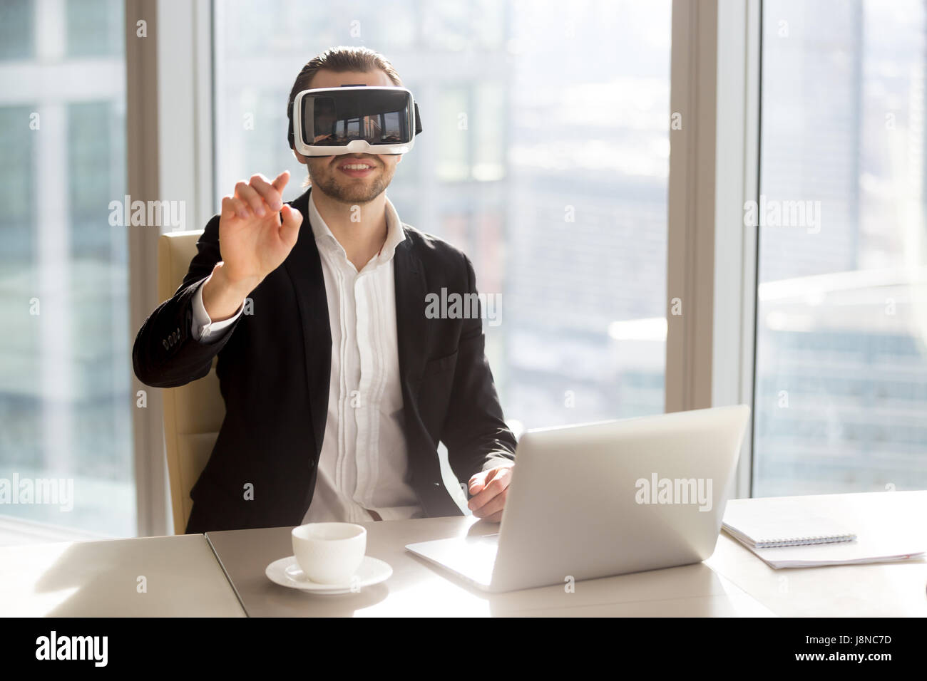 Uomo in cuffia VR toccando oggetti virtuali Foto Stock