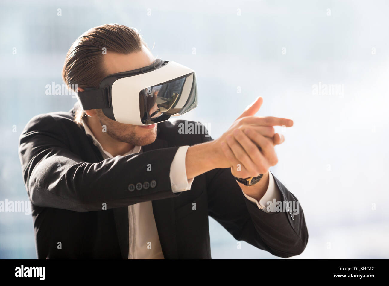 L'uomo gioca nel gioco sparatutto con auricolare VR Foto Stock