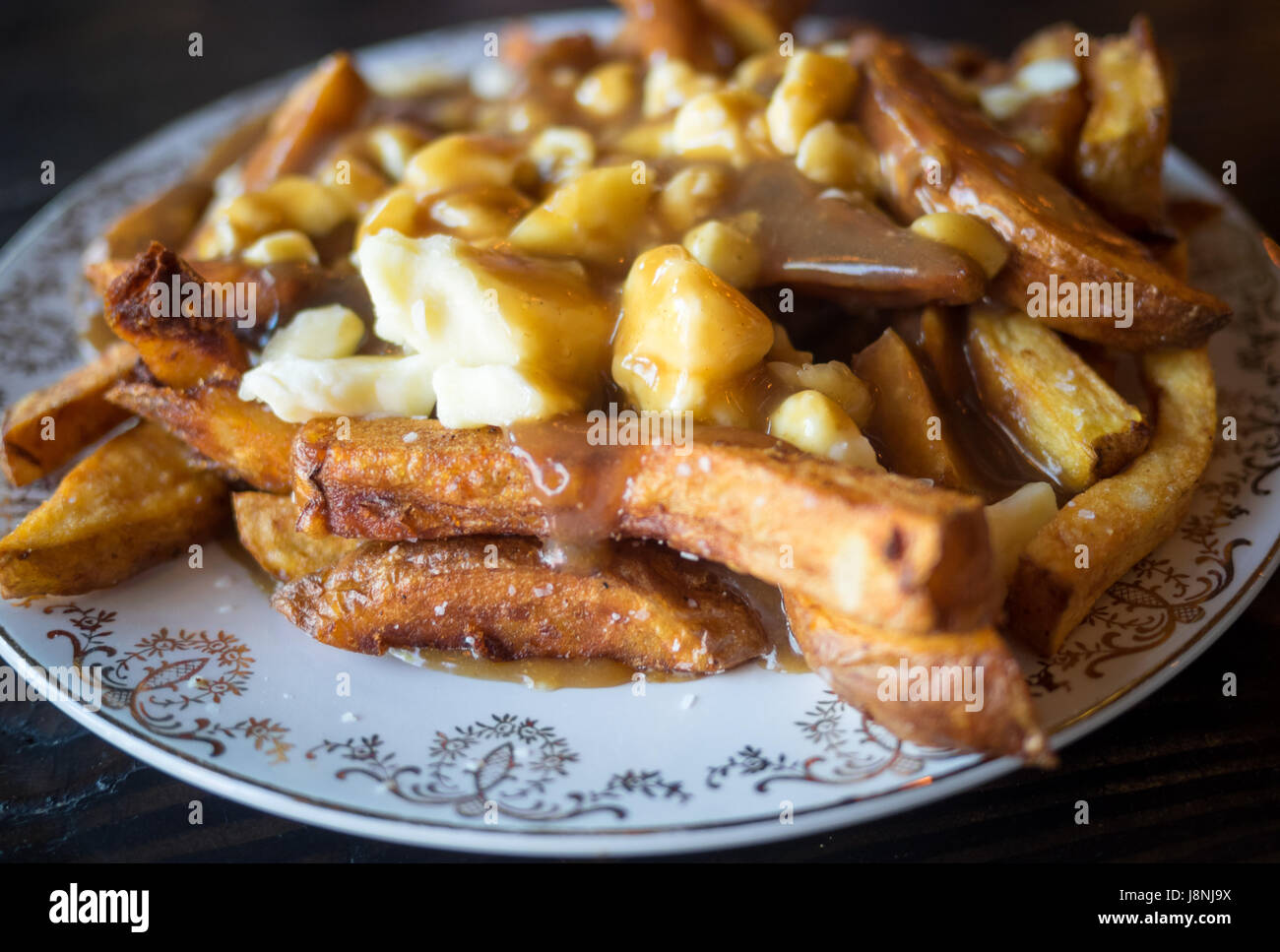 Una piastra di autentica, tradizionale Quebec poutine (patatine fritte, cagliata di formaggio e salsa) da Chartier Ristorante a Beaumont, Alberta, Canada. Foto Stock