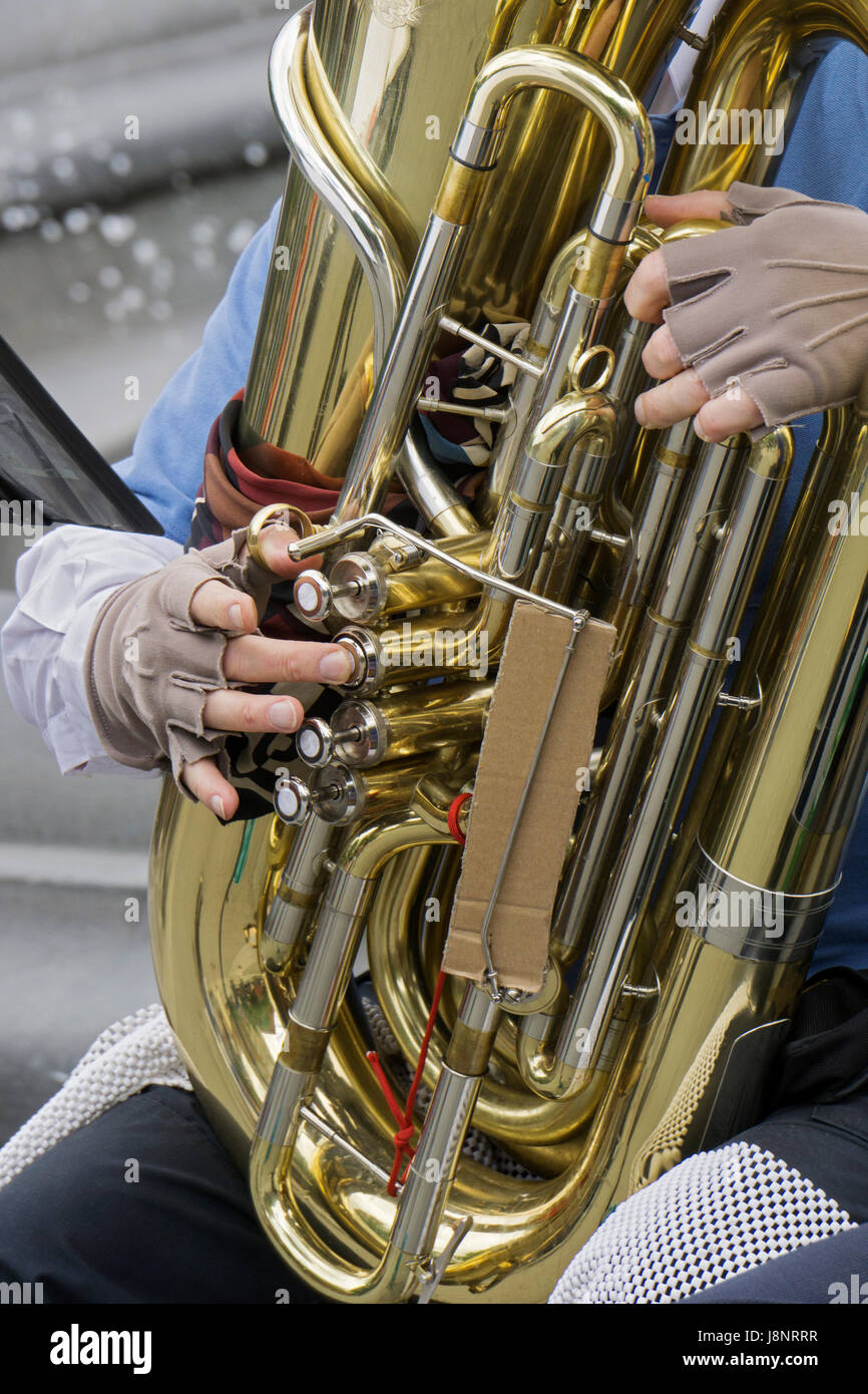 Close up foto delle mani con guanti di un musicista busker nella banda Uni la riproduzione della tuba in Washington Square Park nel Greenwich Village di New York City Foto Stock