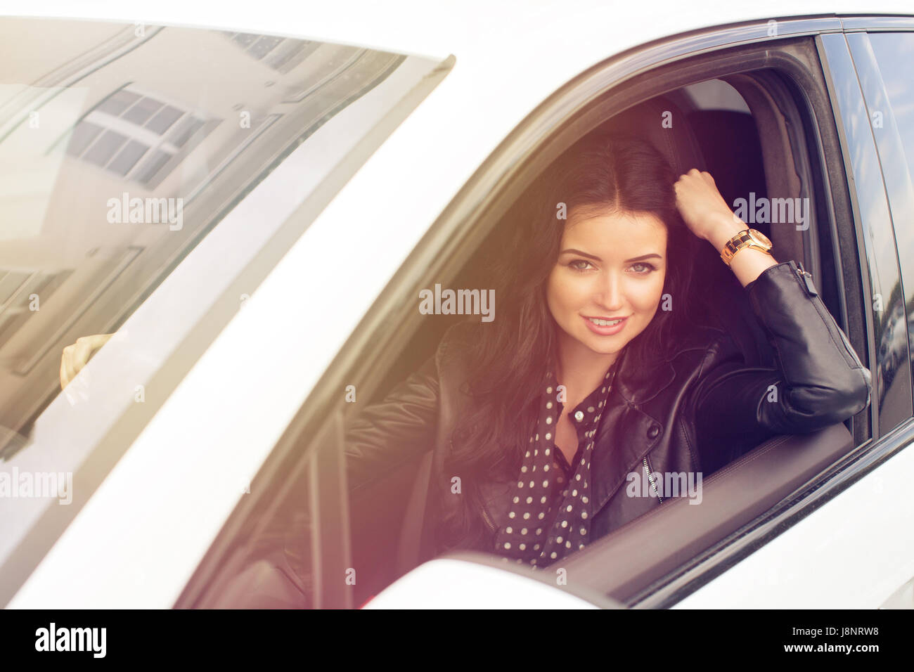 Giovane donna seduta all'interno vettura sorridente in telecamera Foto Stock