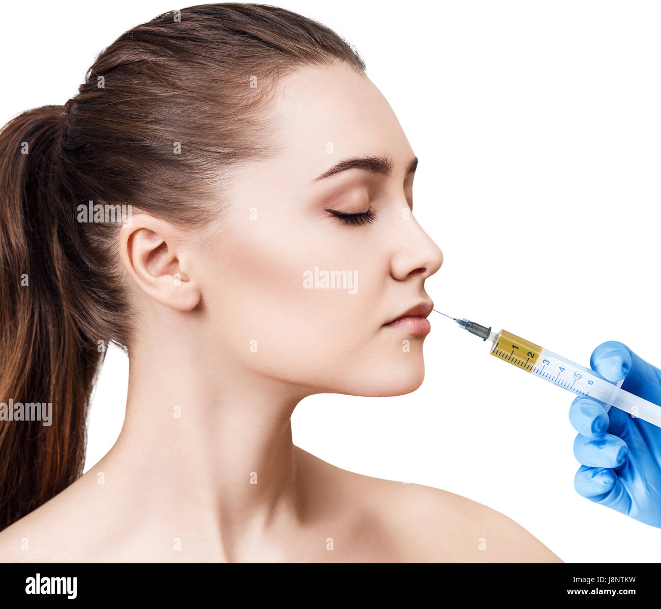 Bella donna ottiene l'iniezione nella sua labbra. Isolato su sfondo bianco. Chirurgia plastica e concetto di bellezza. Foto Stock