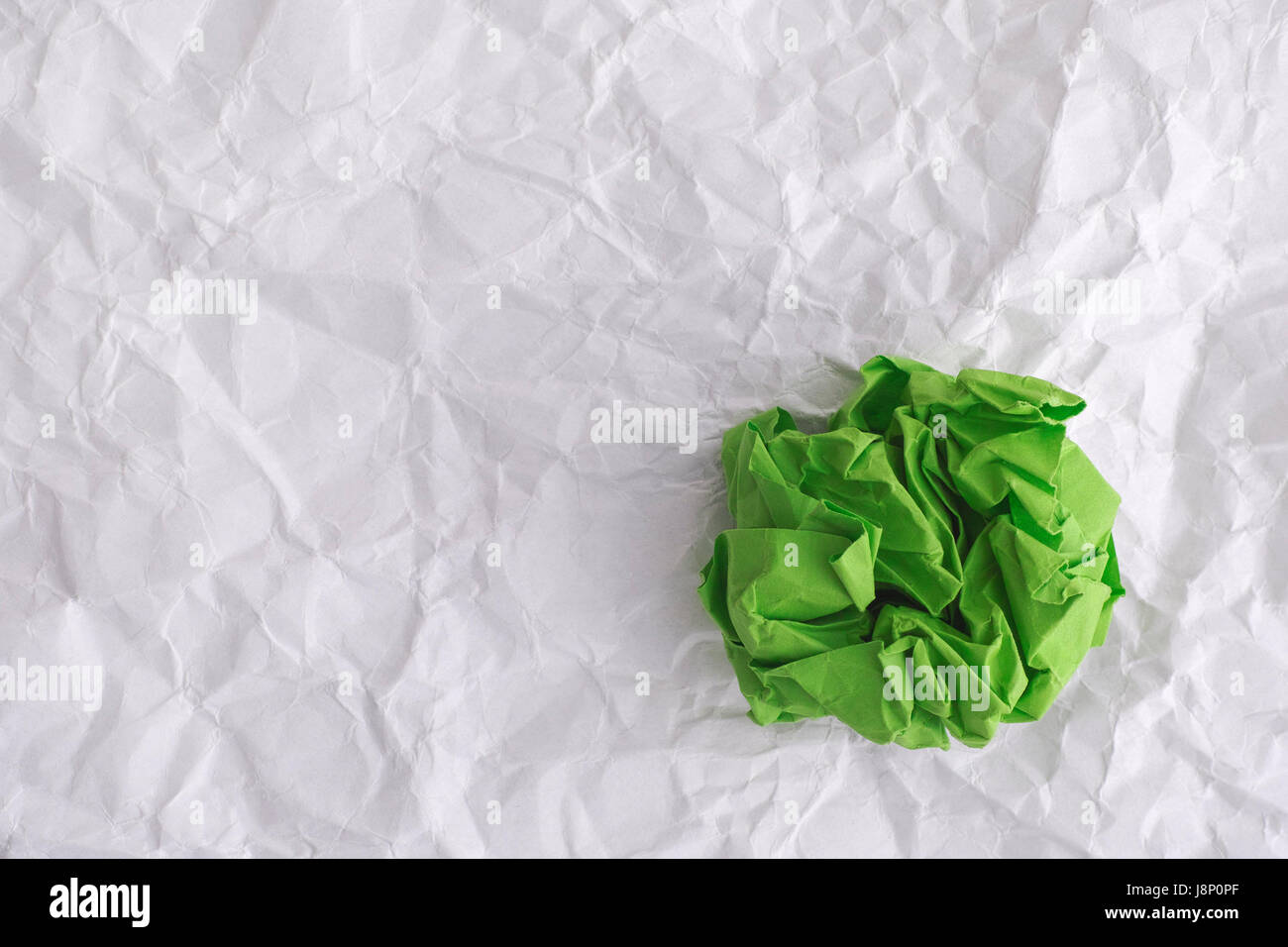 Libro verde sfera su carta sgualcita sfondo. Idea concetto. Foto Stock
