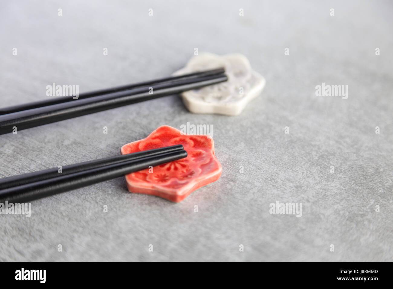 Due paia di bastoncini su ceramica artigianale chopstick poggia Foto Stock
