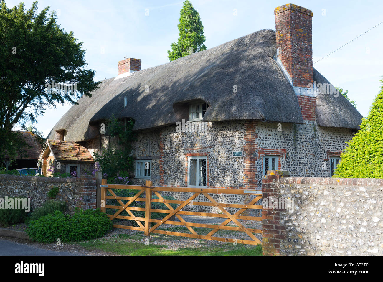 Tradizionale di pietra focaia con tetto in paglia e cottage di mattoni nel villaggio costiero di Chidham, West Sussex, Regno Unito Foto Stock