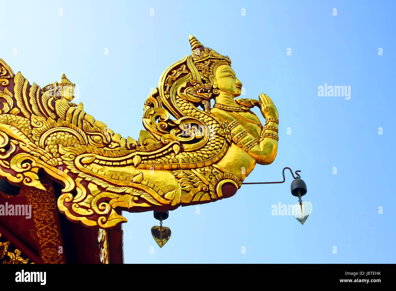 Nativo di stile tradizionale Thai angelo scolpire sulla decorazione del tetto e cielo blu, Golden Kinnaree atto rispetto a pagamento o sawasdee della Thailandia, il mitico ha Foto Stock