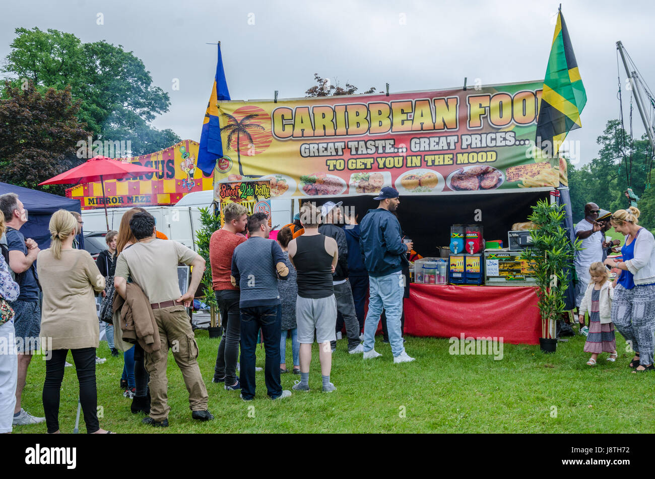 La gente in coda per acquistare cibo formano un cibo caraibico stallo a lettura Carnevale a Prospect Park, la lettura. Foto Stock