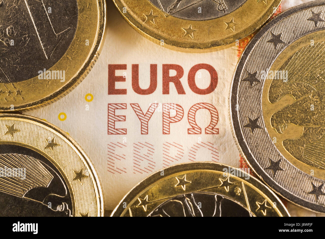Monete metalliche in euro sulla parte superiore di dieci euro carta moneta banca nota Foto Stock