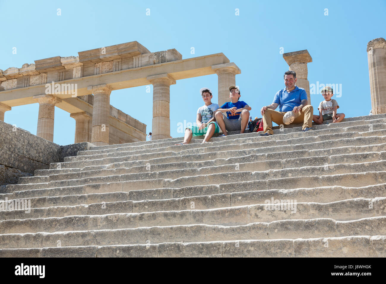 LINDOS, l' isola di Rodi, Grecia - 3 Settembre 2015: Turisti in appoggio su un scale vicino al colonnato di Grand Portico ellenistico dell antica Acrop Foto Stock