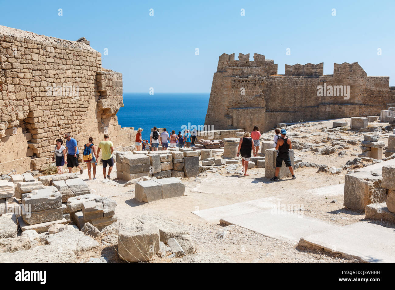 LINDOS, l' isola di Rodi, Grecia - 3 Settembre 2015: turisti visitano le rovine che si affaccia sul blu del Mar Egeo dall'antica acropoli di Lindos, Rodi Foto Stock