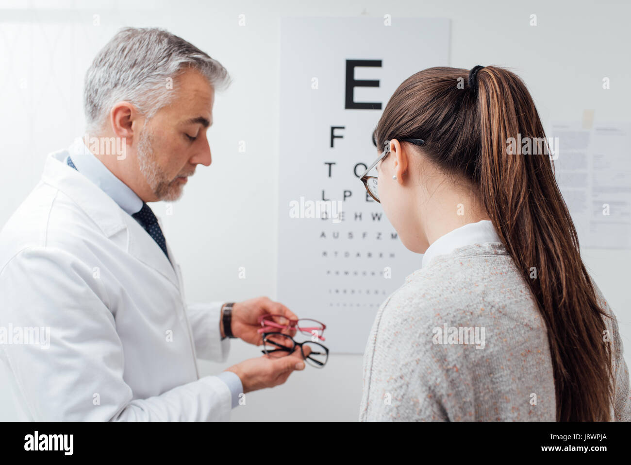 La donna la scelta di un paio di occhiali dopo la visita oculistica, l  oculista è dare a lei un consiglio Foto stock - Alamy