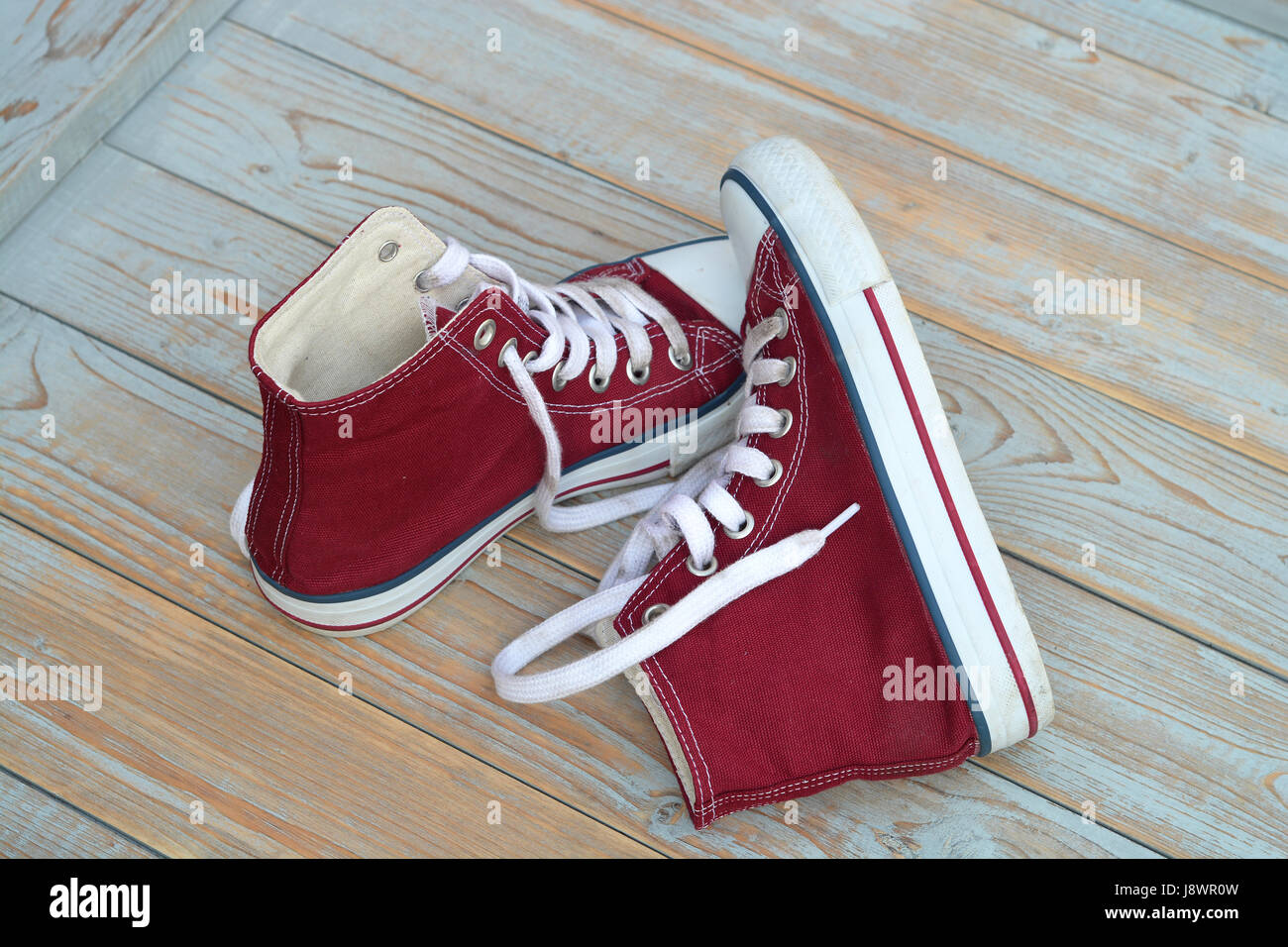 Grunge di legno con sfondo rosso tela vintage sneakers Foto Stock