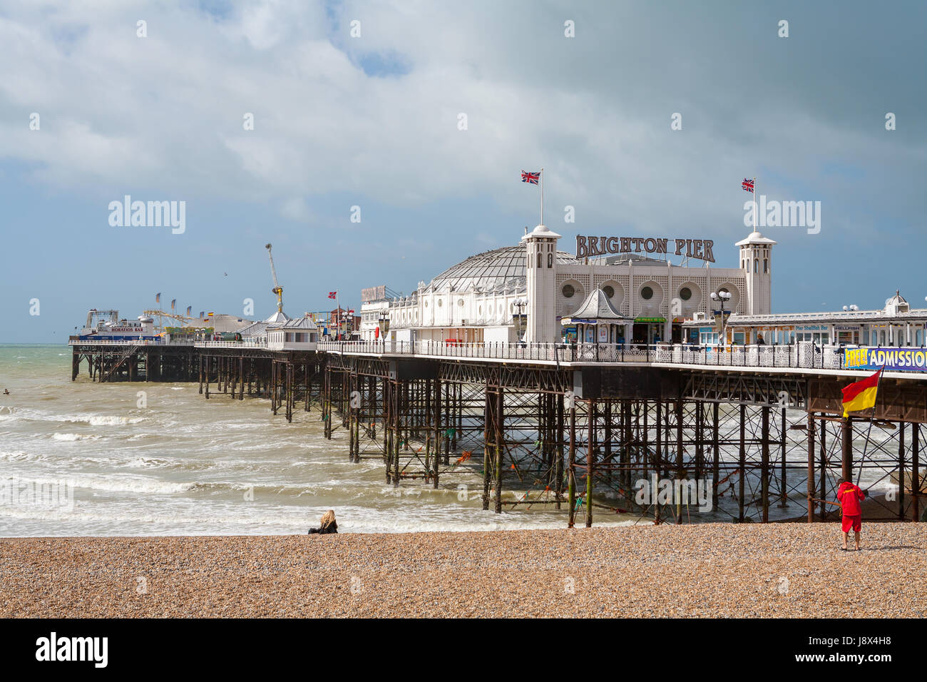 Al molo di Brighton e spiaggia di ciottoli. Brighton, East Sussex, Inghilterra Foto Stock