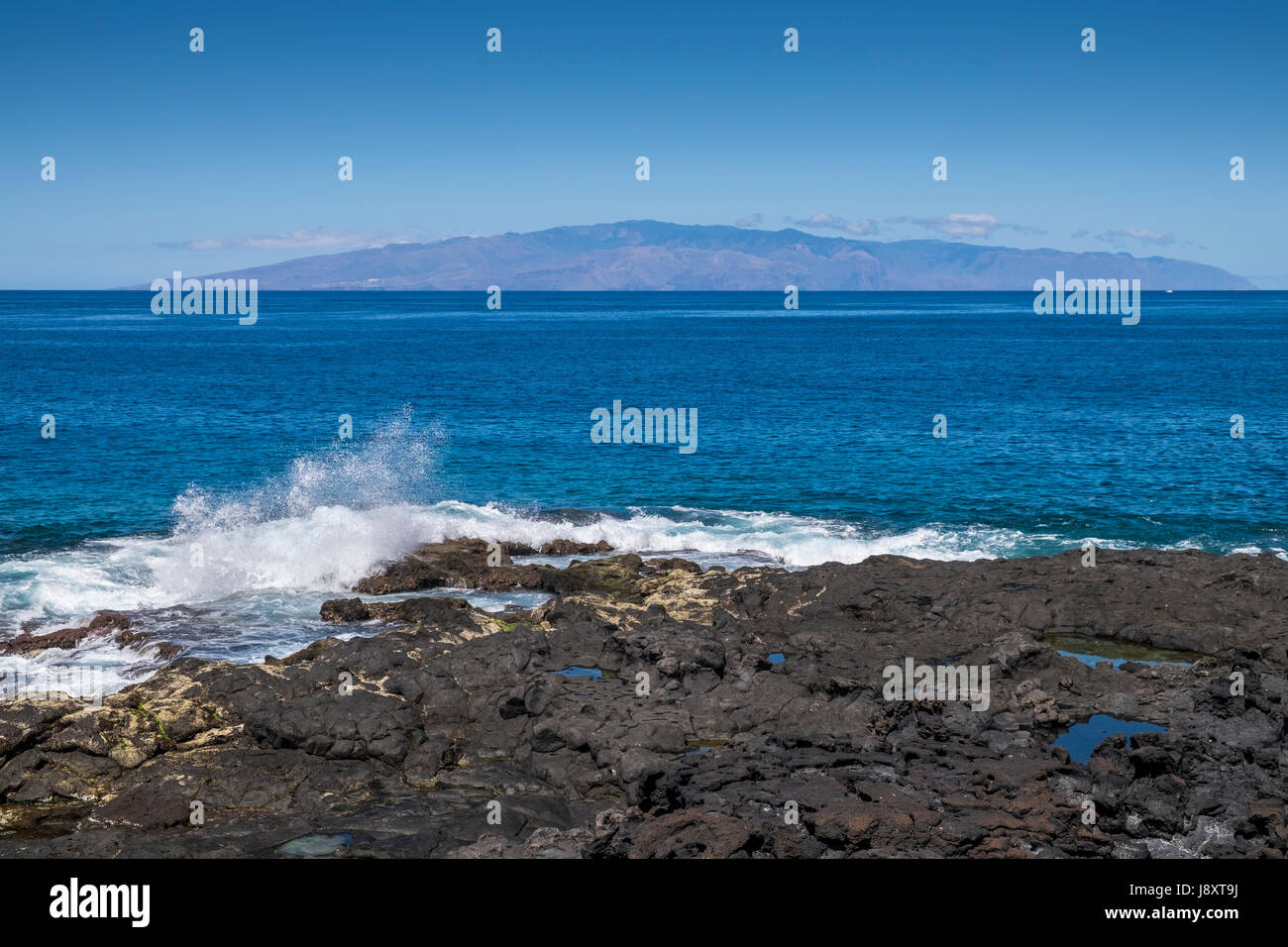 Isola di La Gomera visto dalla costa occidentale di Tenerife su una chiara mattina, Playa San Juan, Isole Canarie, Spagna Foto Stock