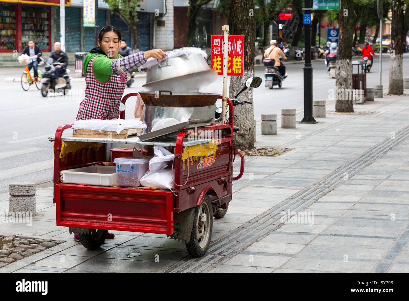 Guilin, Cina. Street Food Vendor per la configurazione del suo carrello, montato su un motociclo. Foto Stock