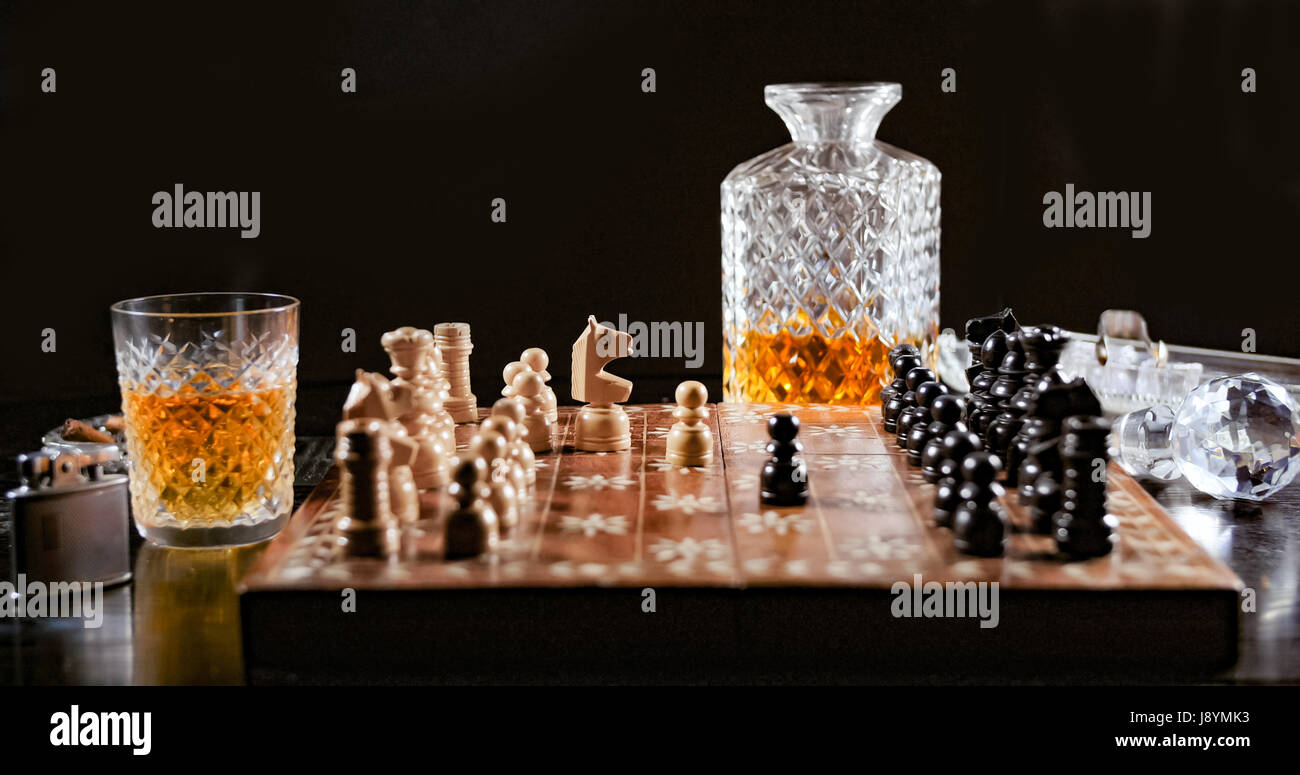 Riproduzione di un gioco di scacchi con un bicchiere di whiskey e un sigaro  Foto stock - Alamy
