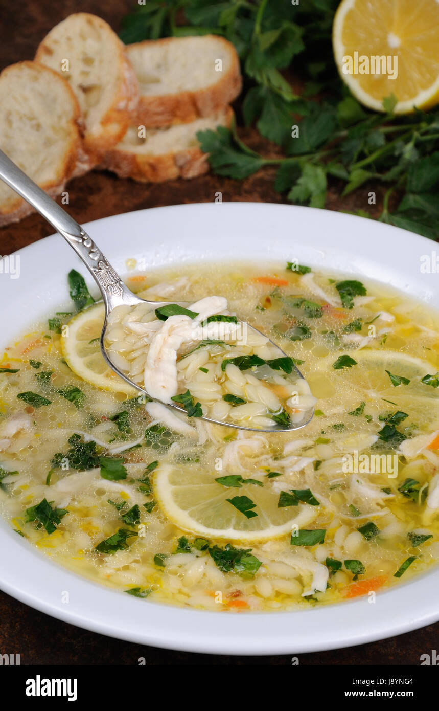 Avgolemono, greca zuppa di pollo con uova di salsa di limone, orzo e fresche foglie di prezzemolo Foto Stock