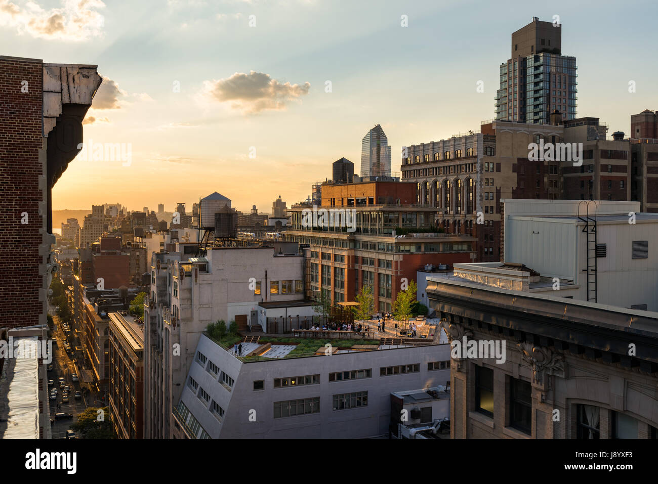 Chelsea tetti in estate la luce del tramonto con grattacieli e torri d'acqua. Manhattan, New York City Foto Stock