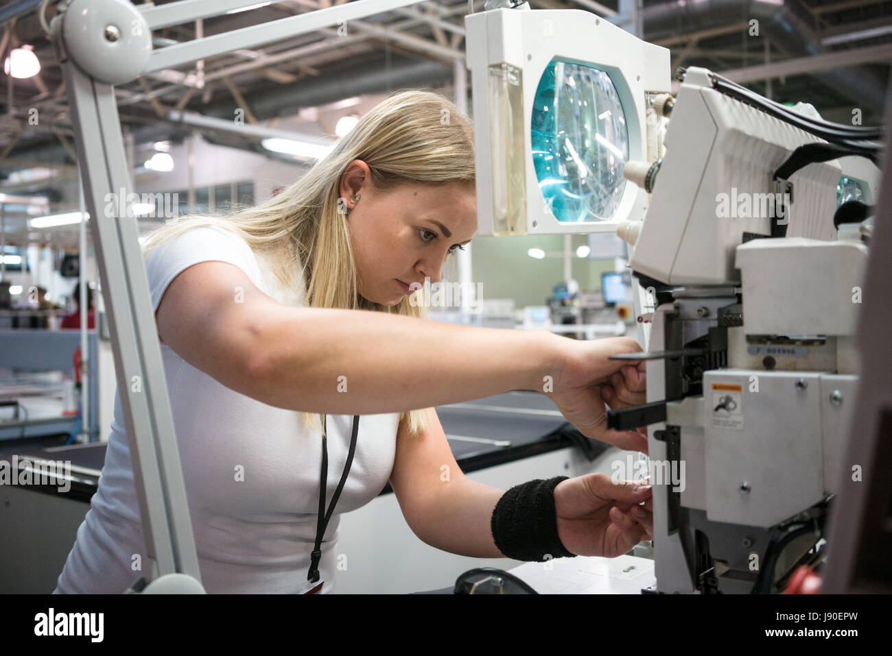 Gaydon, Regno Unito - 08/10/2016. Un dipendente di programmi di una macchina per cucire che stitch la Aston Martin logo sul cuoio per gli appoggiatesta. Foto Stock