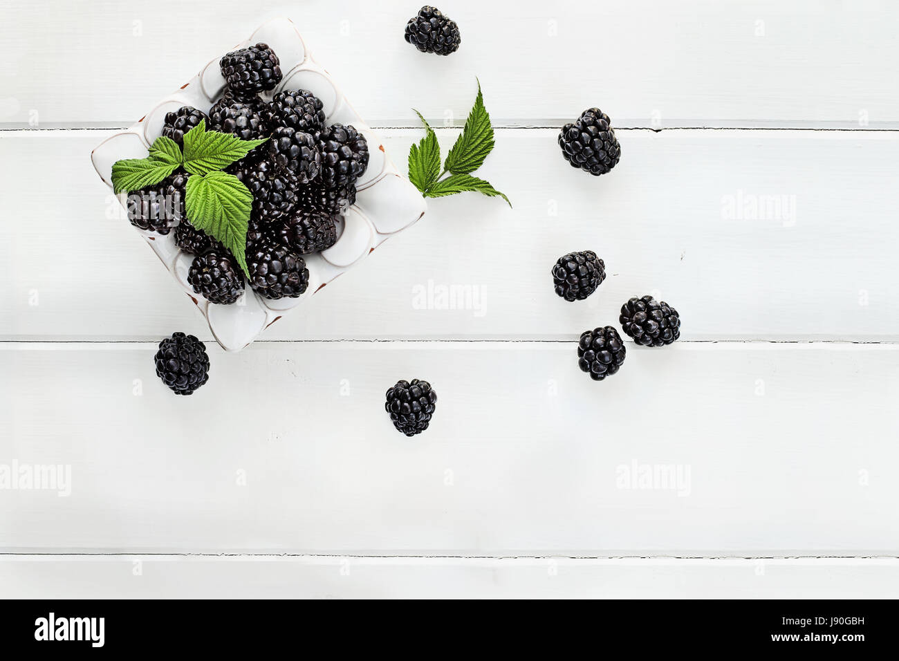 Tettuccio di colpo di fresco frutta blackberry su legno bianco tavolo. Camera per copiare lo spazio. Foto Stock