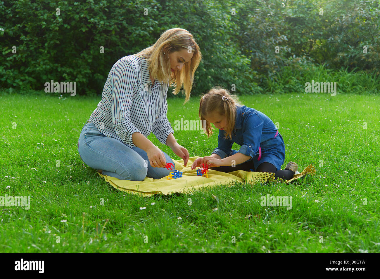 Madre e figlia giocando sull'erba Foto Stock
