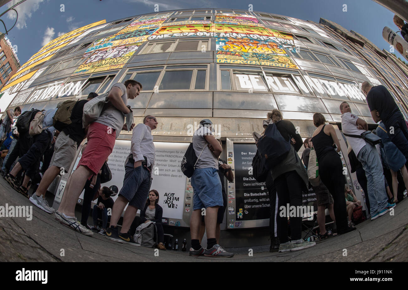 Visitatori stand pranzo nella parte anteriore della street art project "casa" sulla strada Nuremberger a Berlino, Germania, 31 maggio 2017. Gli artisti hanno eseguito le loro idee, graffitis, installazioni e dipinti in più di 100 camere del lungo edificio vuoto. Gli amanti dell'arte hanno potuto visitare i pezzi d'arte nell'ex edificio della banca dal 01 aprile 2017. La temporanea art house si chiuderà di nuovo all'inizio del nuovo mese. Escavatori si sposta e strappare l'edificio verso il basso come previsto, compresi i pezzi d'arte. Un nuovo edificio di appartamenti sarà costruita nella nuova creazione vacante lo Foto Stock