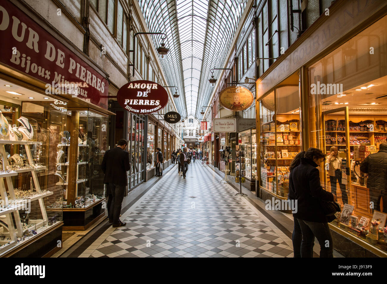 Il passaggio Jouffroy a Parigi, con un pavimento di mattonelle, skylight, e l'amour de Pierres shop sulla sinistra. Foto Stock
