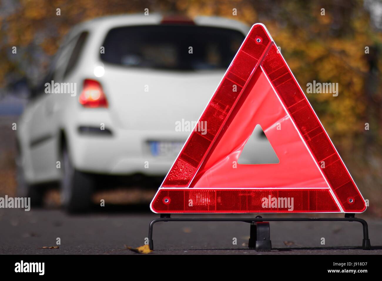 Triangolo riflettente di fronte ad una ripartizione per auto Foto Stock