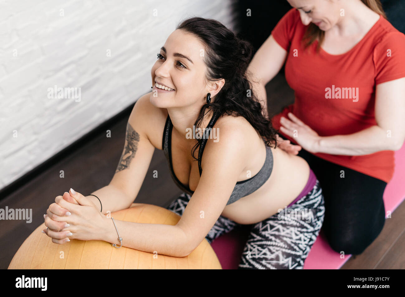 Donna incinta godendo di un massaggio alla schiena da lei ostetrica Foto Stock