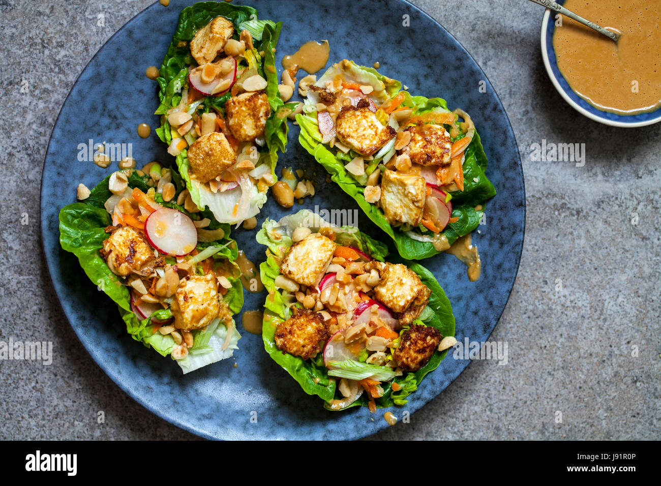 Un letto di insalata con tofu fritto, insalata e salsa di arachidi Foto Stock