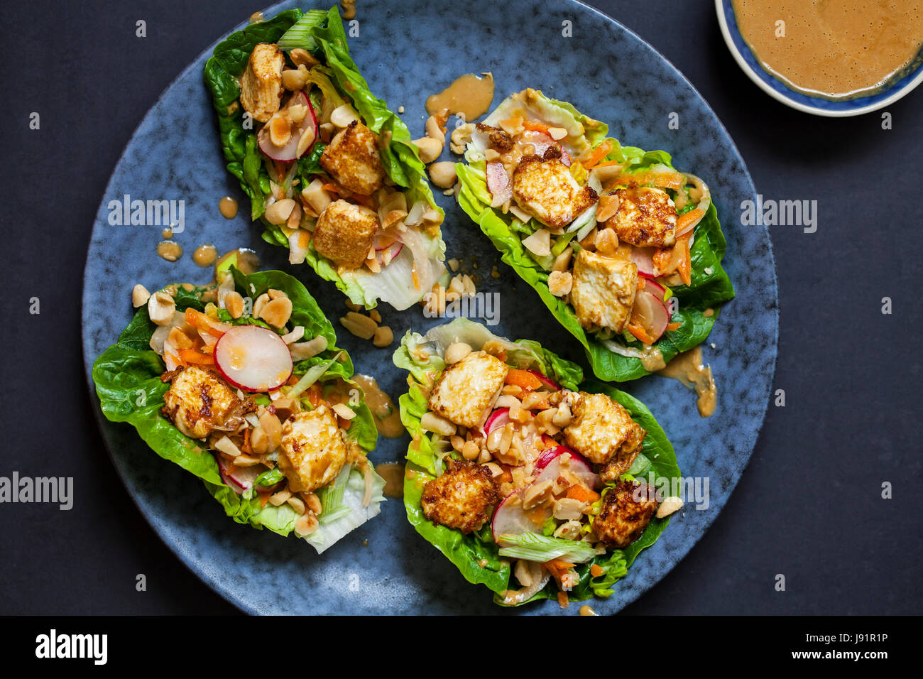 Un letto di insalata con tofu fritto, insalata e salsa di arachidi Foto Stock
