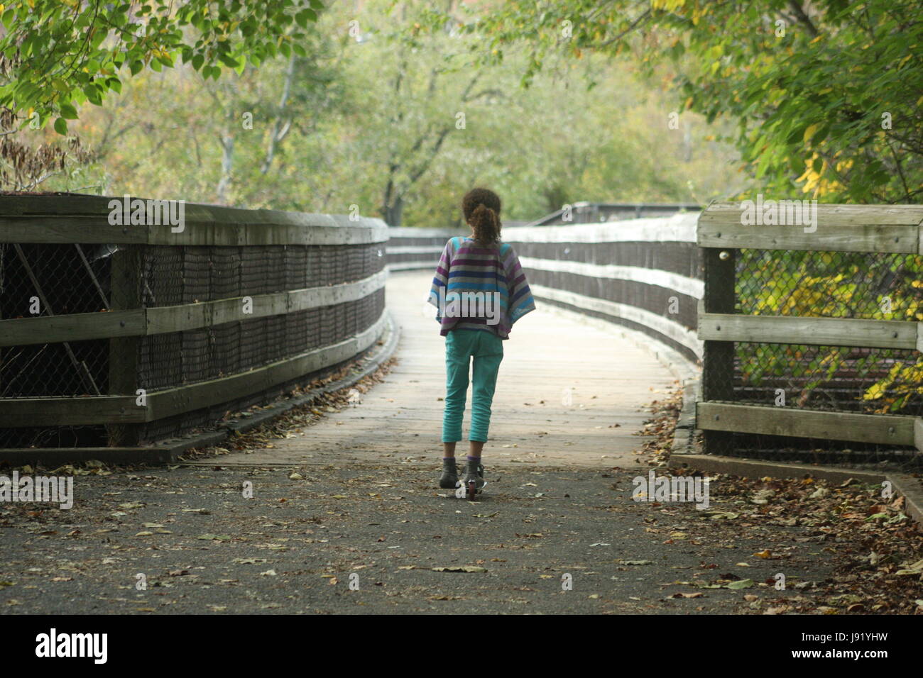 Bambina scooter di equitazione su park's trail Foto Stock