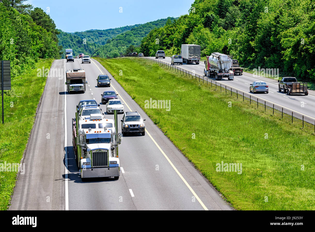 Un costante mix di camion, auto e SUV rotolare giù per una strada interstatale nel Tennessee orientale. Aumento di calore dal marciapiede dà un fresco scintillante FEP Foto Stock