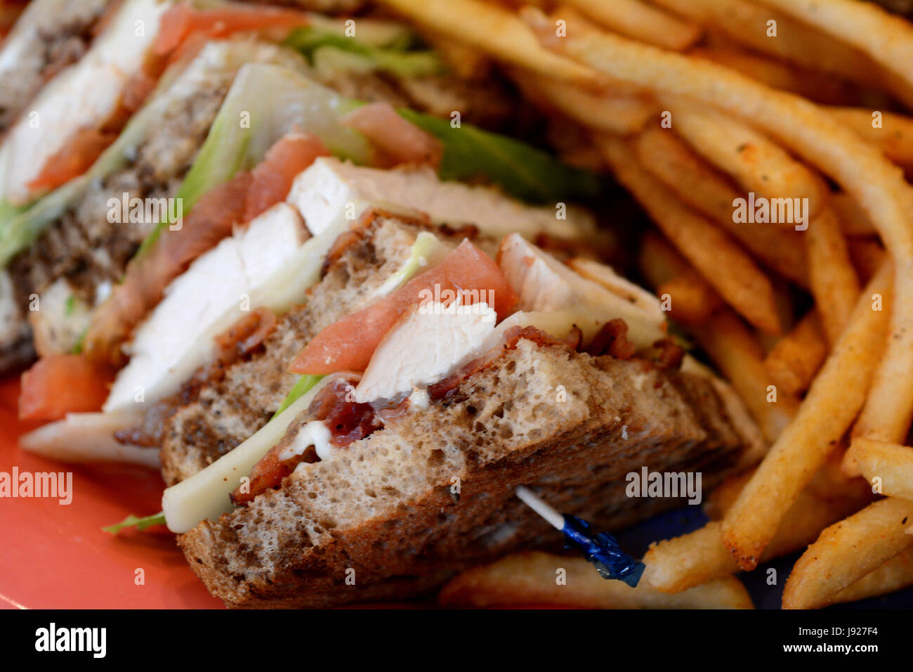 Club sandwich sulla piastra con patate fritte Foto Stock