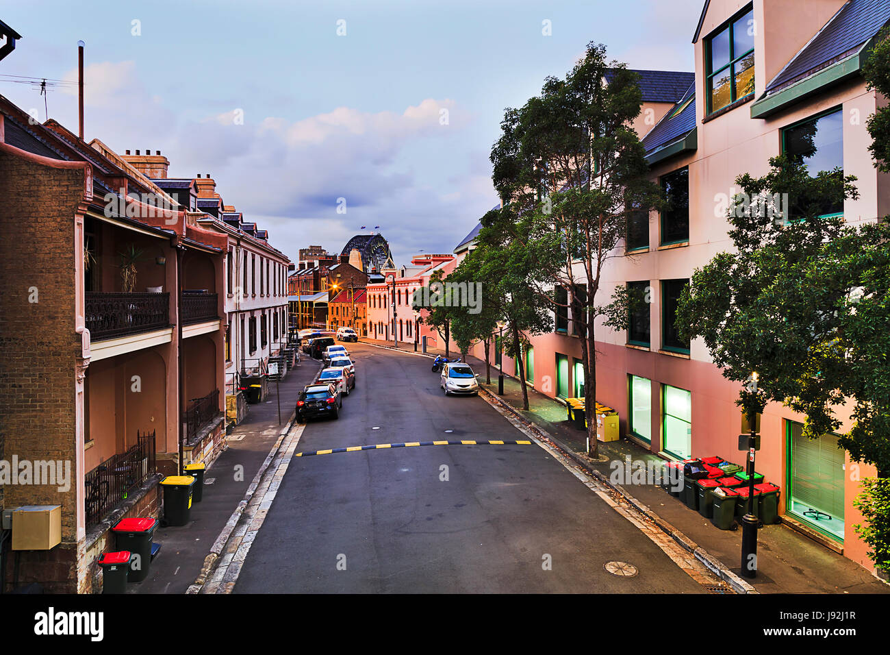 Sydney sobborgo più anziano rocce al Tramonto da sopra. Tranquilla strada residenziale con facciate di edifici storici e macchine parcheggiate verso il porto Foto Stock