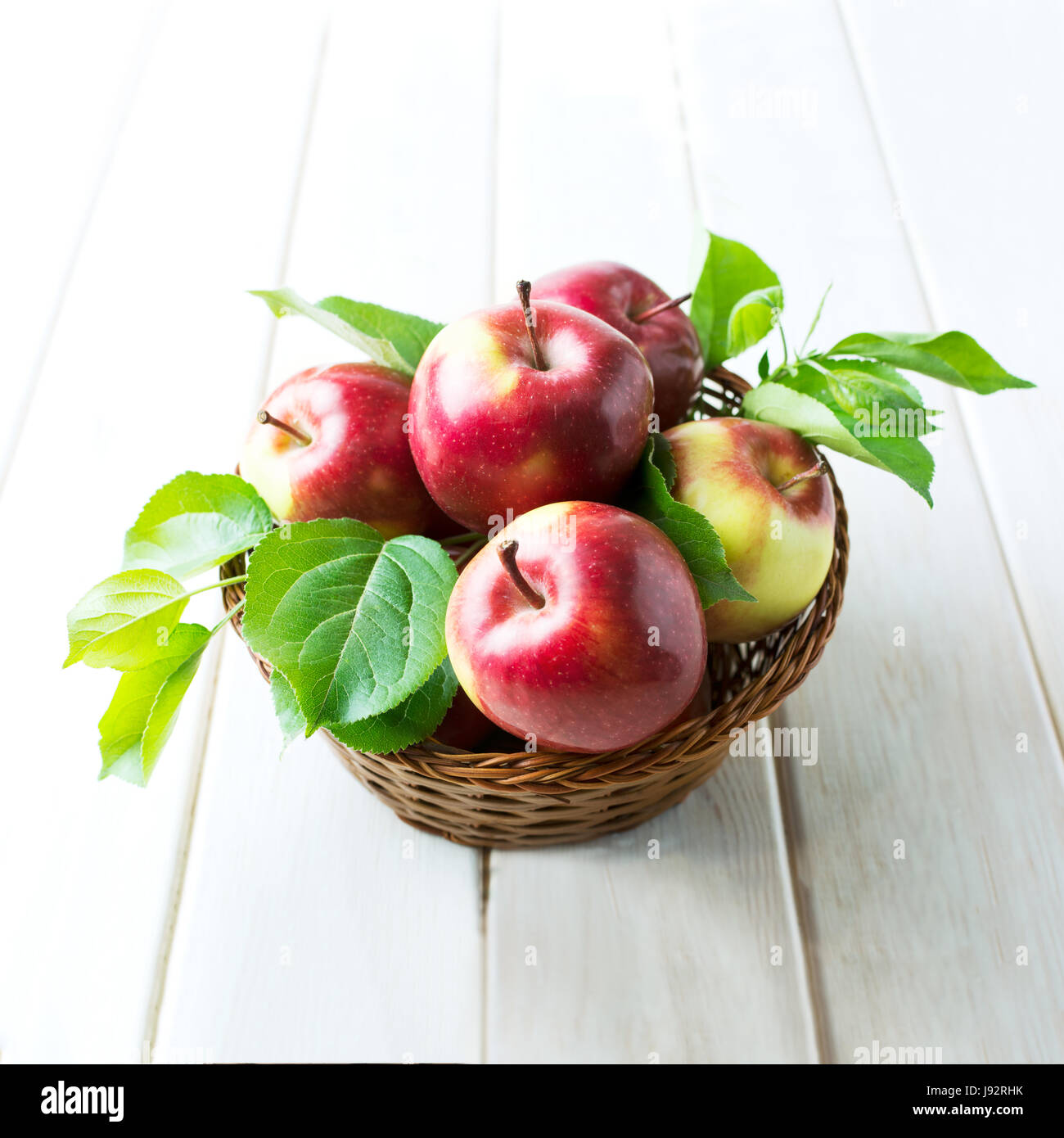 Le mele rosse nel cesto di vimini. Frutta organica, cibo sano. Foto Stock