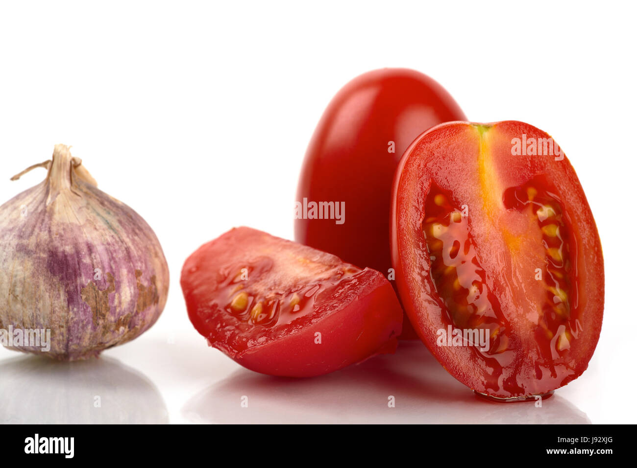Pomodori freschi con aglio e cipolla contro uno sfondo bianco Foto Stock