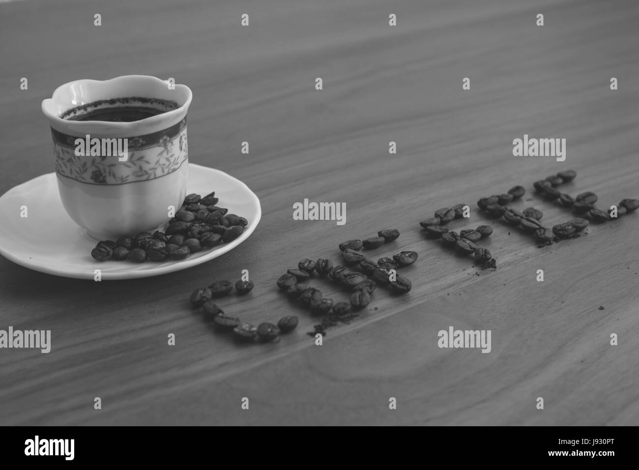 Caffè torrefatto in grani, sparsi sul tavolo e scritto il caffè in una tazza di caffè tostato, oltre caffè, marrone del legno texture di sfondo, legno, lastre di tabl Foto Stock