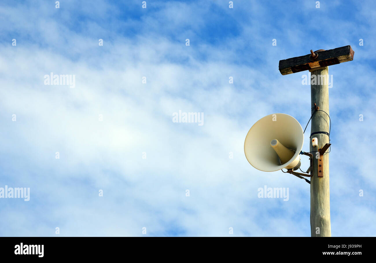 Altoparlante esterno sistema di avvertimento sul palo del telegrafo contro un cielo blu sullo sfondo. Copia spazio per il testo. Foto Stock