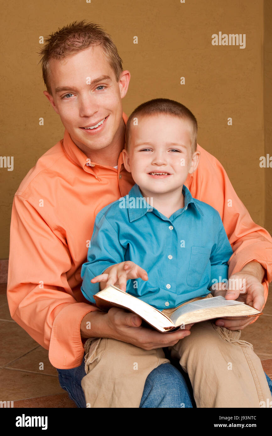 Felice padre amorevole di lettura con suo figlio. Foto Stock