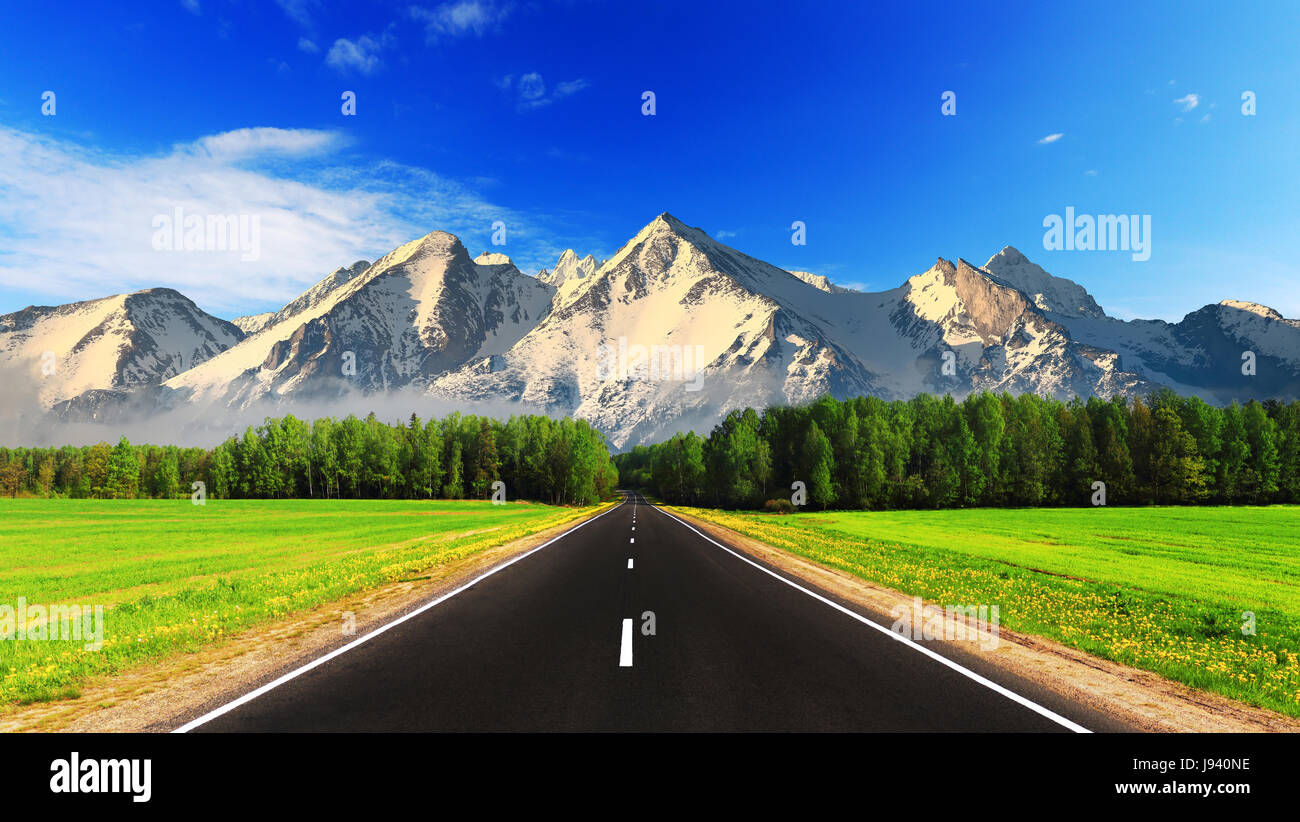 Strada vuota su sfondo di montagna. Giornata di sole in Alaska. Estate paesaggio di montagna. Viva il trasporto dello sfondo. Foto Stock